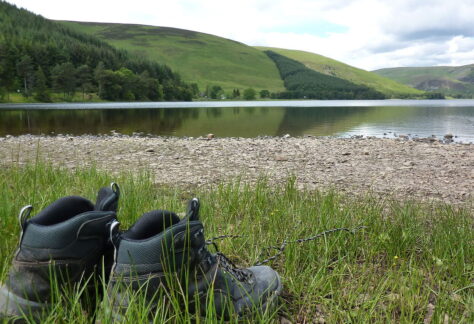 walking boots beside a lake